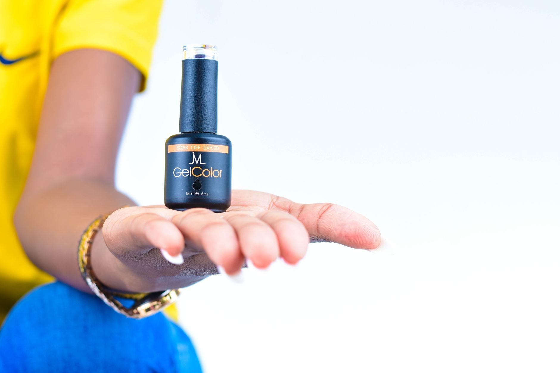 Hand holding a gel polish bottle in the studio